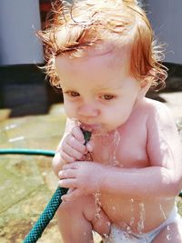 Close-up of cute girl holding water hose