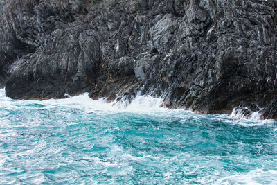 Sea waves splashing on rock formation