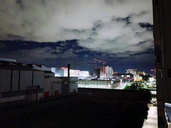 Buildings in city against storm clouds