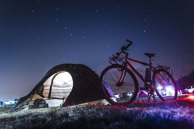 Low angle view of bicycle against clear sky at night
