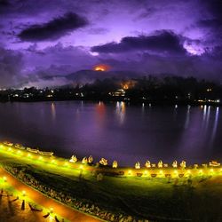 View of illuminated lake against cloudy sky