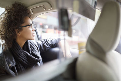 Woman looking away while traveling in car