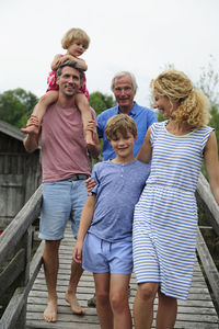 Happy family walking together on boardwalk in summer