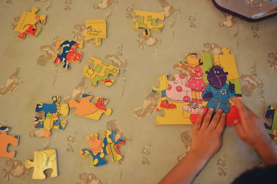 Cropped image of child with puzzle at table