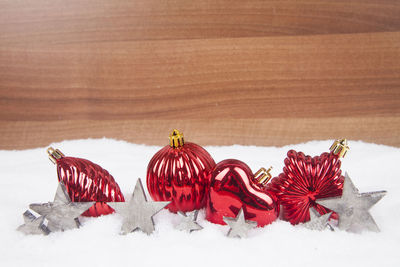 High angle view of red baubles with star shape decoration on snow