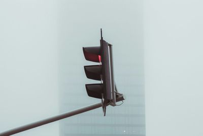 Low angle view of stoplight against sky