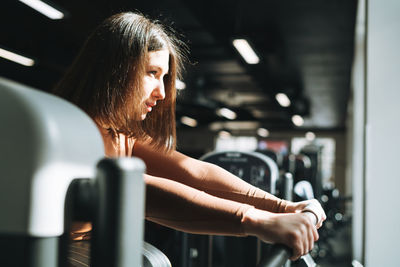 Young fitness brunette woman training for cardio equipment at the gym