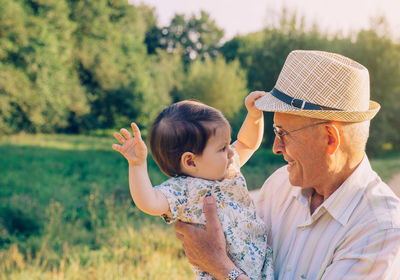 Close-up of grandfather carrying granddaughter at park