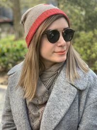 Portrait of young woman wearing rayban sunglasses standing outdoors