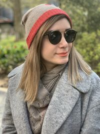 Portrait of young woman wearing sunglasses standing outdoors