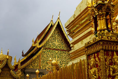 Low angle view of temple amidst buildings against sky