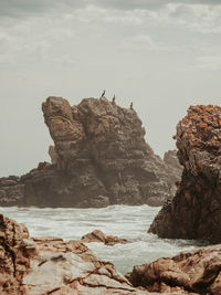 Rocks on beach against sky