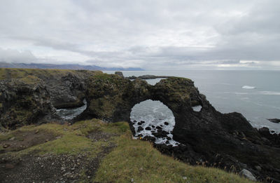 Rock formations by sea against sky