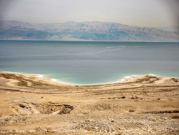 Scenic view of sea and mountains against sky