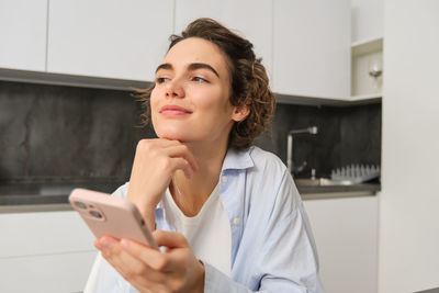 Young woman using mobile phone at home