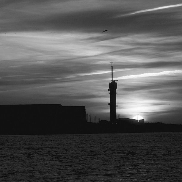 architecture, building exterior, built structure, sky, waterfront, sunset, water, silhouette, sea, cloud - sky, tower, city, bird, scenics, lighthouse, nature, cloud, river, rippled, outdoors