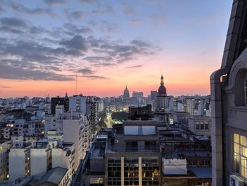 Buildings in city during sunset