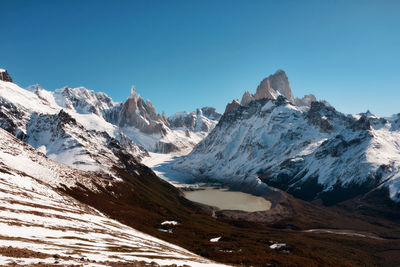 Scenic view of snowcapped mountains against clear blue sky