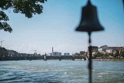 Close-up of city by river against sky