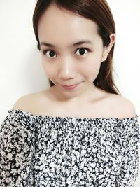 Portrait of young woman against white background