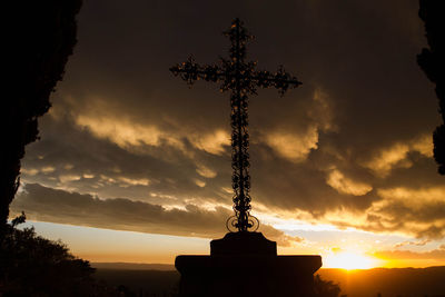 Low angle view of silhouette cross against sky during sunset