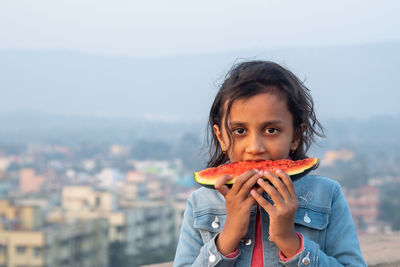 Portrait of man eating food in city