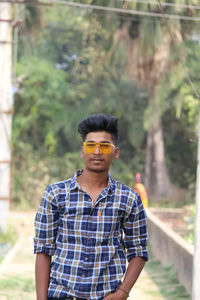 Portrait of young man wearing sunglasses standing outdoors