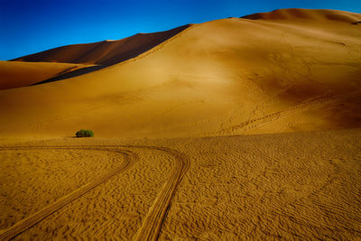 Sand dunes in desert against sky