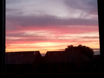 Silhouette buildings against sky during sunset