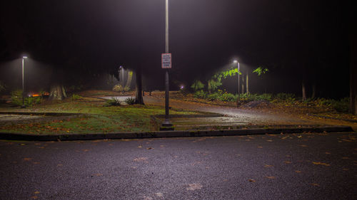 Illuminated road against sky at night