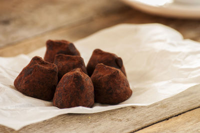 Close-up of brown chocolates on wax paper