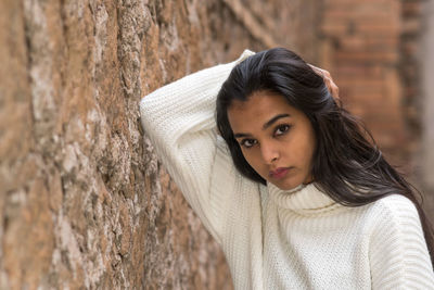 Portrait of woman against tree trunk