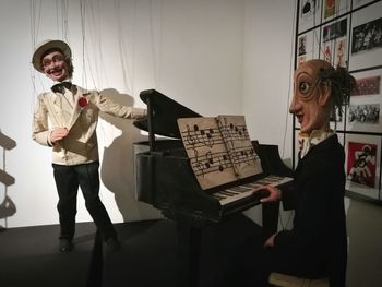 Full length of smiling young woman playing piano