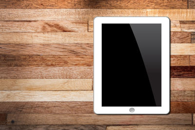 Directly above shot of digital tablet on wooden table