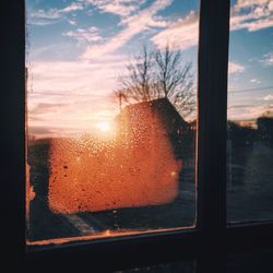 Close-up of condensed glass window during sunset