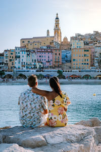 Rear view of couple sitting on water