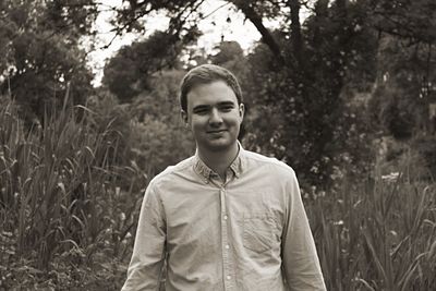 Portrait of man standing amidst plants