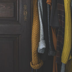 Close-up of clothes hanging by wooden door
