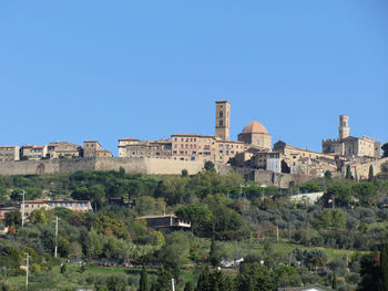 Buildings in city against blue sky