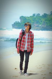 Rear view of woman standing at beach