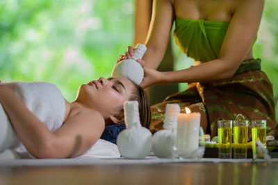 Woman giving forehead massage to customer in spa