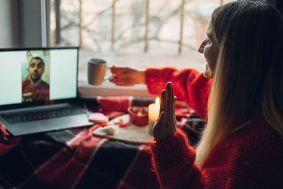 Midsection of woman using phone on table