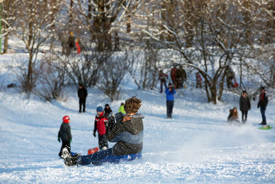 Boy sliding on snow covered landscape