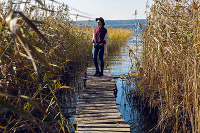 Rear view of woman walking on boardwalk