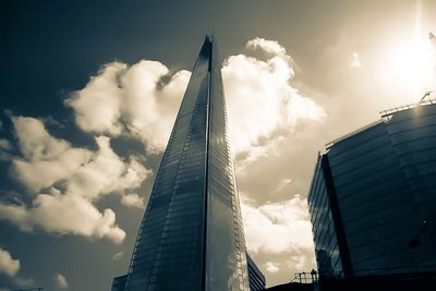 Low angle view of modern building against cloudy sky