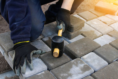 Paver master. man lays paving stones in layers. garden brick pathway paving by professional paver 