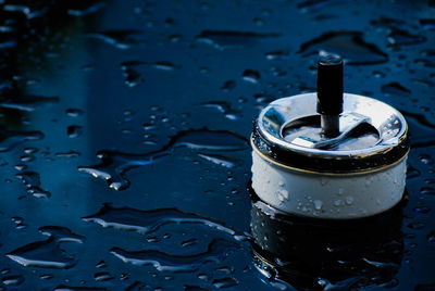 Close-up of ashtray on wet table