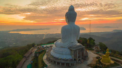 High angle view of buddha statue against cloudy sky during sunset