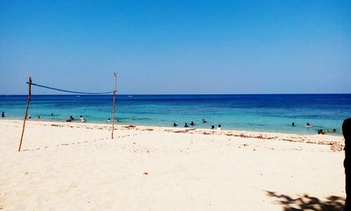 Scenic view of beach against clear blue sky