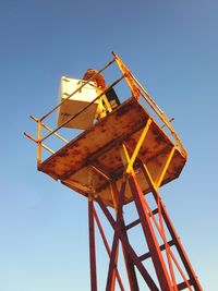Low angle view of rusty tower against clear blue sky